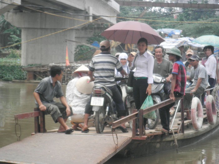 Người dân đi lại bằng chiếc phà nhỏ, làm bằng bê tông, hiện nay đang vào mùa nước to, tiềm ẩn nguy cơ tai nạn rất cao.